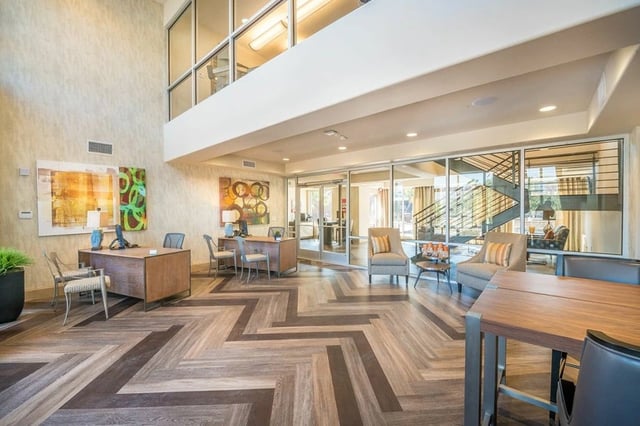 Reception desk and seating area in a modern apartment building lobby.