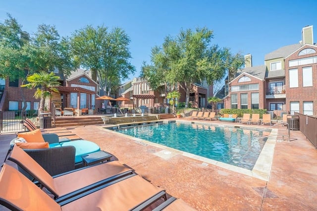 Resort-style swimming pool with lounge chairs and outdoor seating.