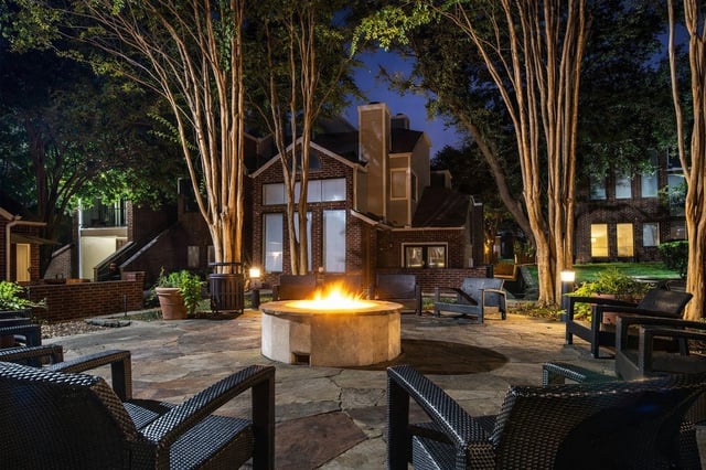 Outdoor seating area with a fire pit at night