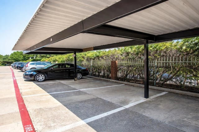 Covered parking spaces with cars parked, outdoor.