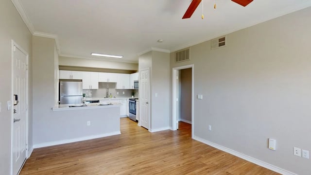 Open concept living area and kitchen with stainless steel appliances and granite countertops.