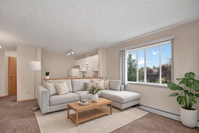 Living room with a sectional sofa, coffee table, and large window.