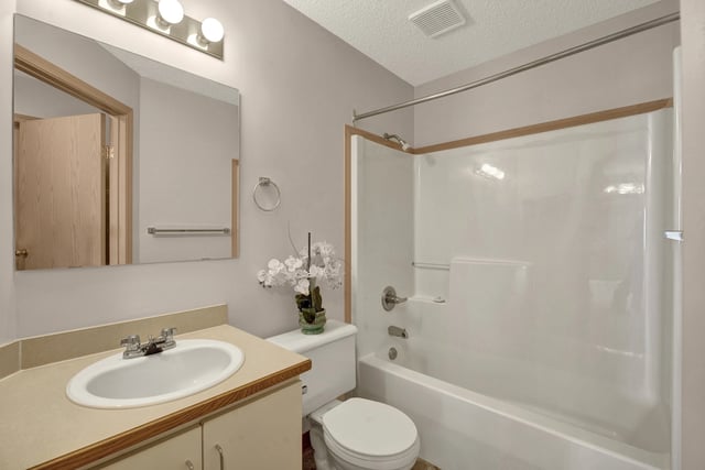 Bathroom with vanity, sink, toilet, and bathtub/shower combo.