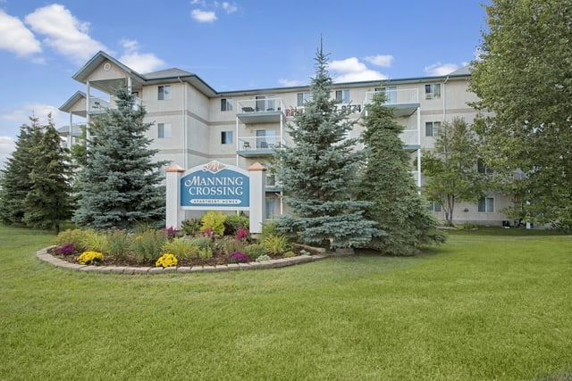 Manning Crossing Apartment Homes building exterior with trees and landscaping.