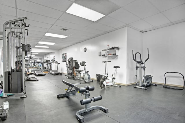 Gym with cardio machines, weight machines, and free weights.