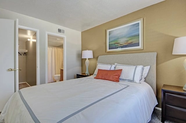 Bedroom with a queen-size bed, nightstand, and closet.