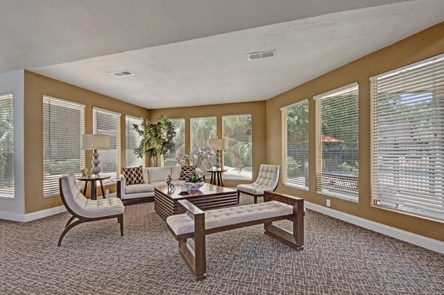 Spacious living room with large windows, comfortable seating, and a coffee table.