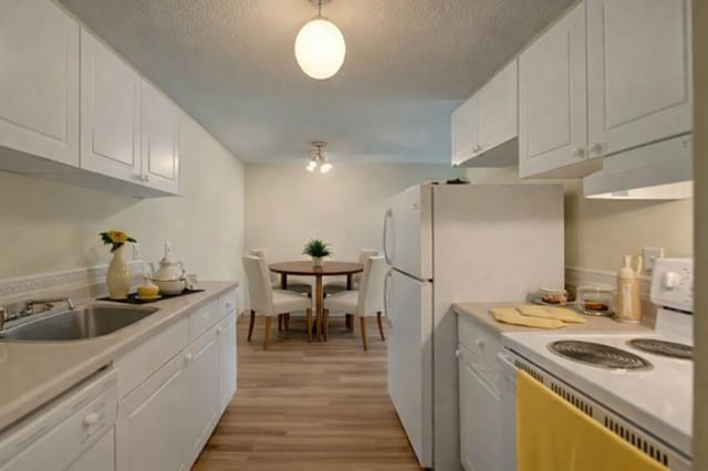 Kitchen and dining area with white cabinets and appliances.
