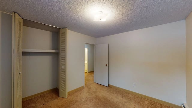 Empty bedroom with a closet and a doorway to a bathroom.