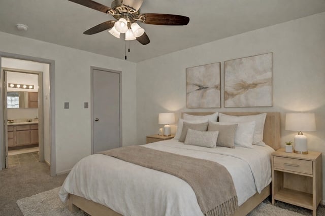 Bedroom with a queen-size bed, nightstands, and ceiling fan.