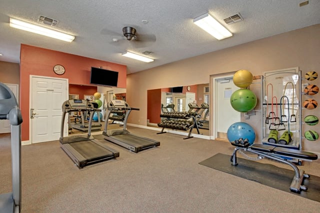 Treadmills and weight equipment in apartment complex gym.