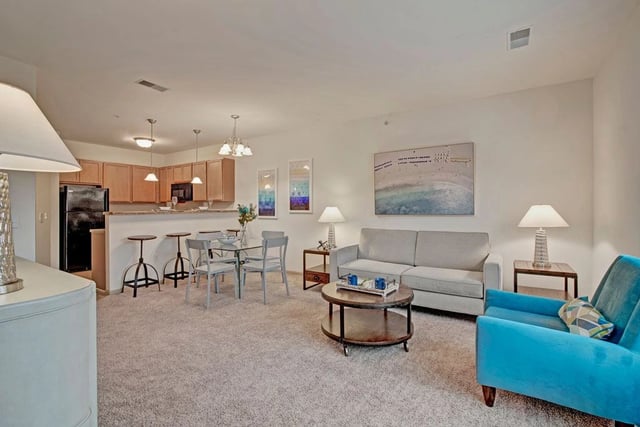 Living room and kitchen area with dining table and bar stools.