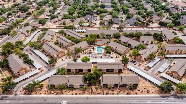 Aerial view of apartment buildings and a swimming pool area.