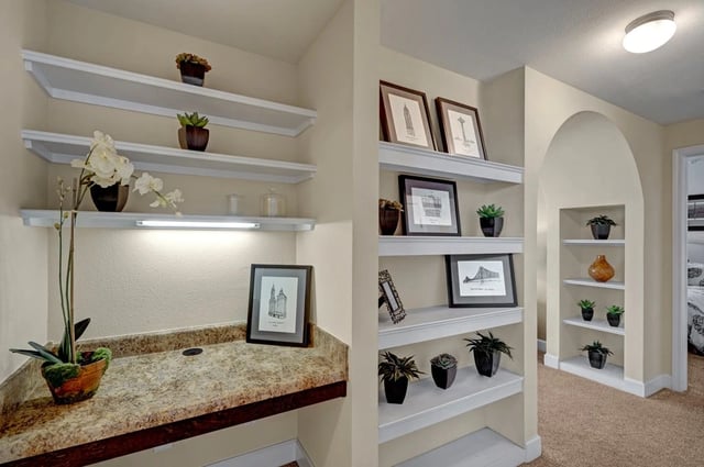 Built-in shelving and desk area with decorative items.