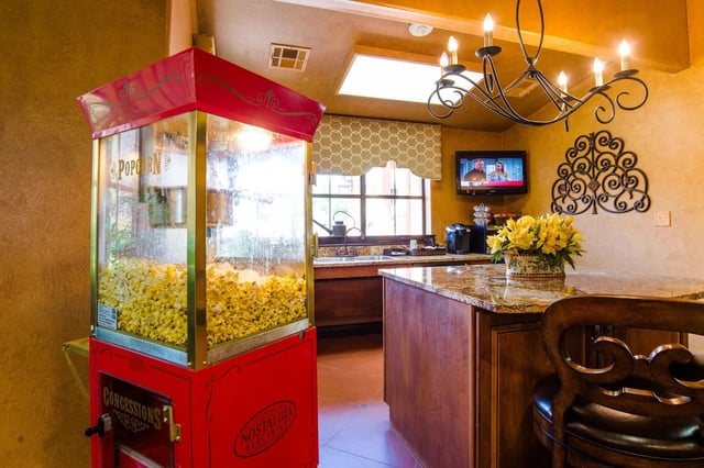 Popcorn machine and kitchen counter with flowers in a multifamily property amenity area.
