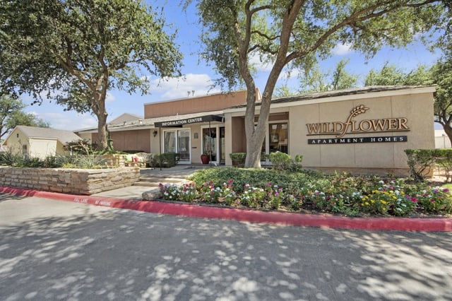 Exterior view of the Wildflower Apartments information center with landscaped grounds.