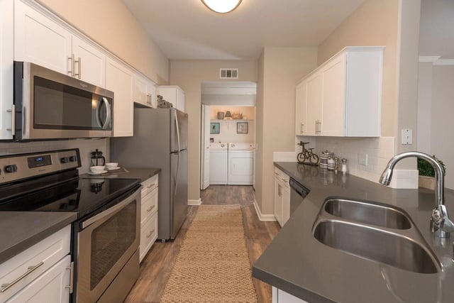 Modern kitchen with stainless steel appliances and granite countertops.