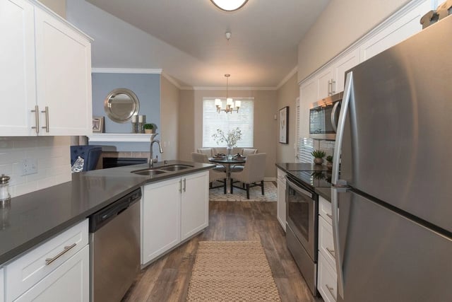Modern kitchen with stainless steel appliances and dining area.