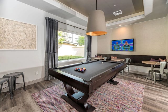 Community lounge with a billiards table and TV.