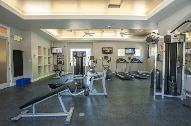 Fitness center with treadmills, weight machines, and free weights.