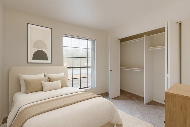 A cozy bedroom featuring a queen-size bed, large window, and a spacious closet.
