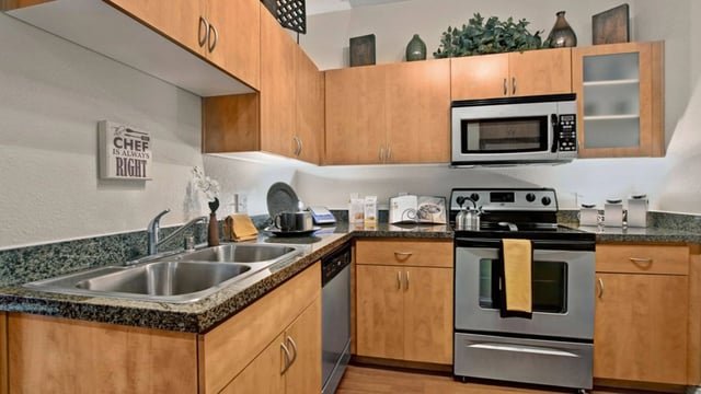 Kitchen with stainless steel appliances, granite countertops, and light wood cabinets.
