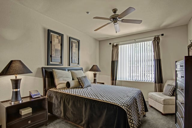 Bedroom with a queen-size bed, nightstand, dresser, and ceiling fan.