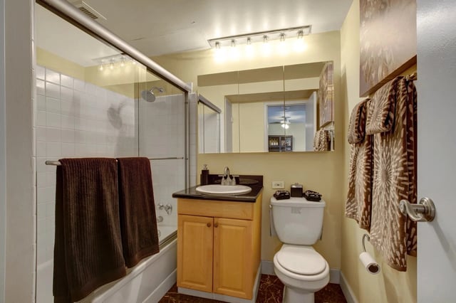 Bathroom with a vanity, toilet, and shower/tub combo.