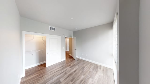 Empty bedroom with a closet and two doors.