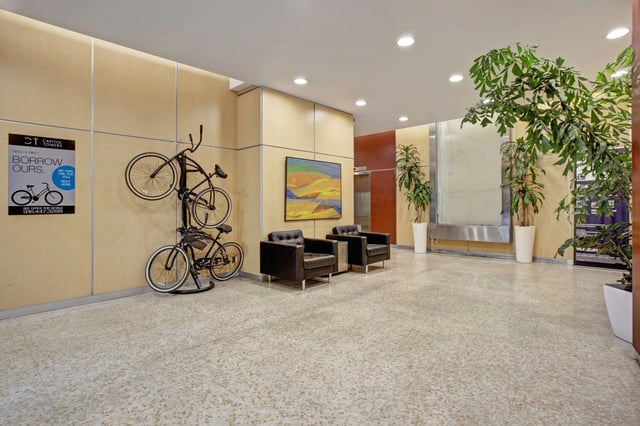 Lobby with bicycle rack, artwork, seating, and plants.