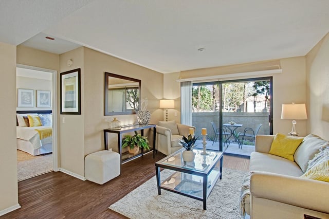Spacious living room with a view of the patio, opening to a bedroom.