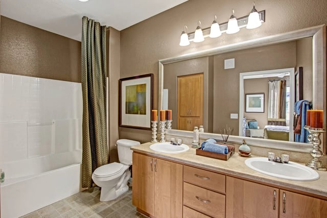 Bathroom with dual vanity, toilet, and bathtub.