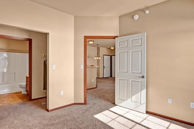 Interior view of an apartment, showing a living room, bathroom, and hallway.