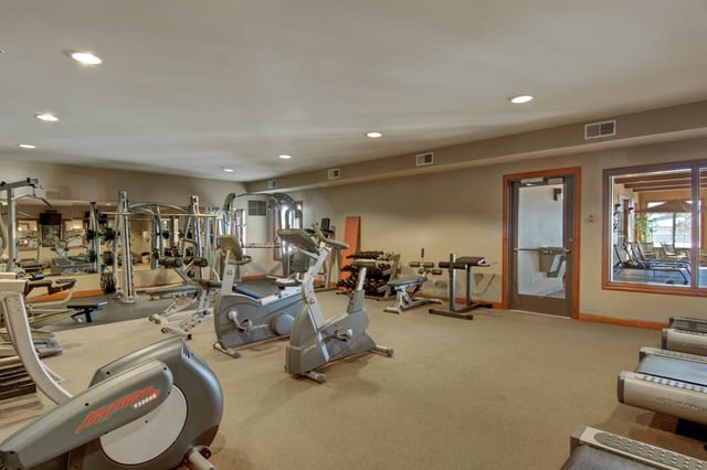 Fitness center with cardio machines, weight racks, and free weights.