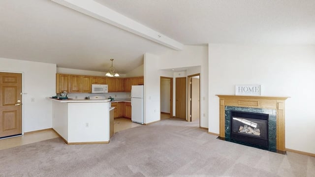 Living room with fireplace and kitchen area