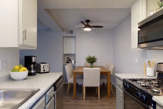 Kitchen and dining area with a table and chairs, a coffee maker, toaster, and a microwave.