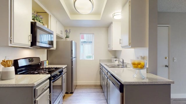 Modern kitchen with stainless steel appliances and granite countertops.