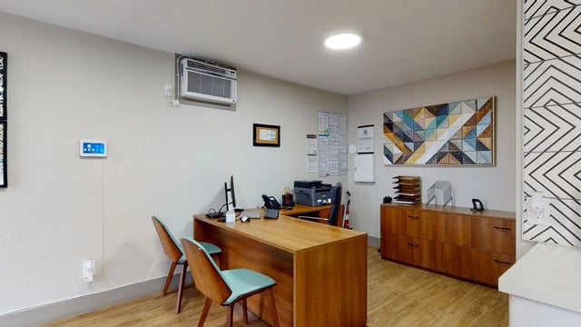 Reception desk with computers, printers, and phones.