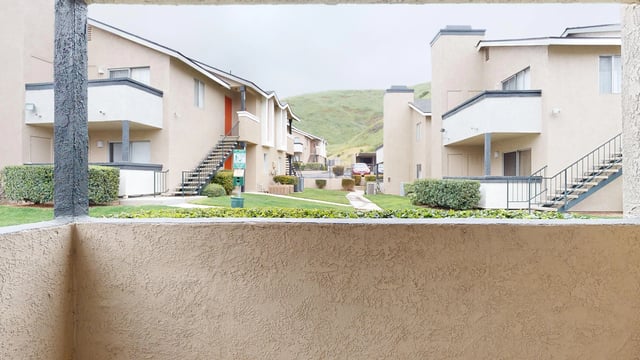 Exterior view of apartment buildings with exterior staircases and landscaping.