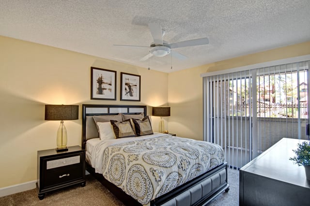 Primary bedroom with king-size bed, two nightstands with lamps, and ceiling fan.