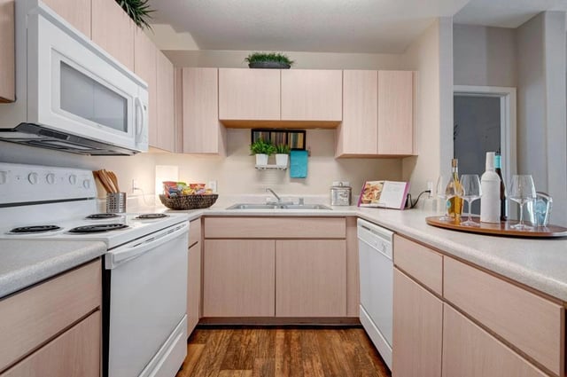 Kitchen with white appliances and light wood cabinets.