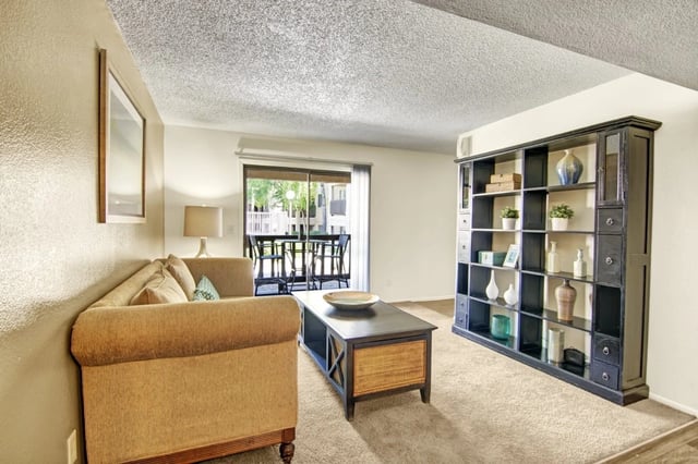 Living room with sofa, coffee table, and bookshelf