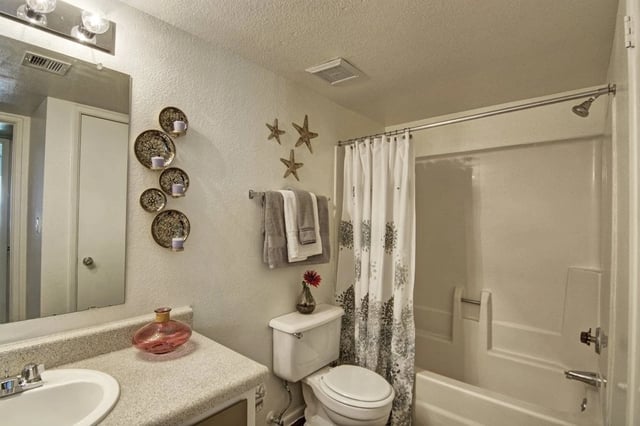 Bathroom with a toilet, sink, and shower/tub combo.
