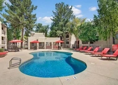 Swimming pool with lounge chairs and red umbrellas
