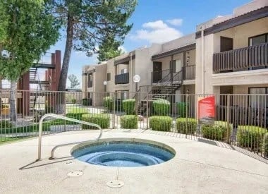 Hot tub spa area with apartment buildings in the background.