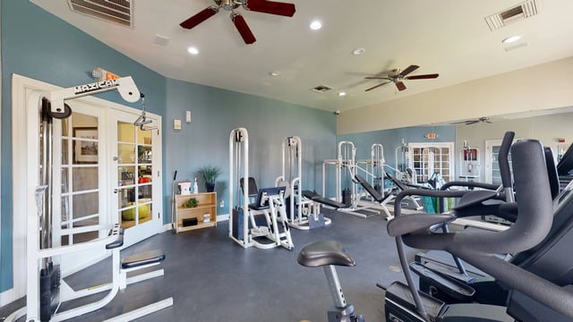 Fitness center with weight machines and cardio equipment.