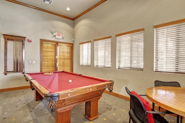 Community room with a pool table and seating area.
