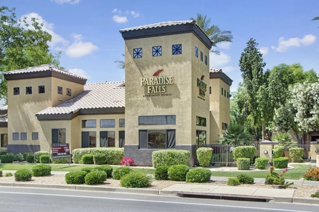 Paradise Falls Apartment Homes building exterior with manicured bushes and landscaping.