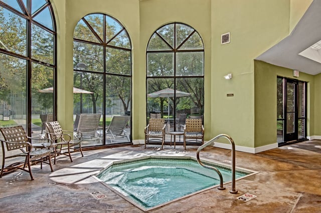 Indoor spa with seating and large windows overlooking trees