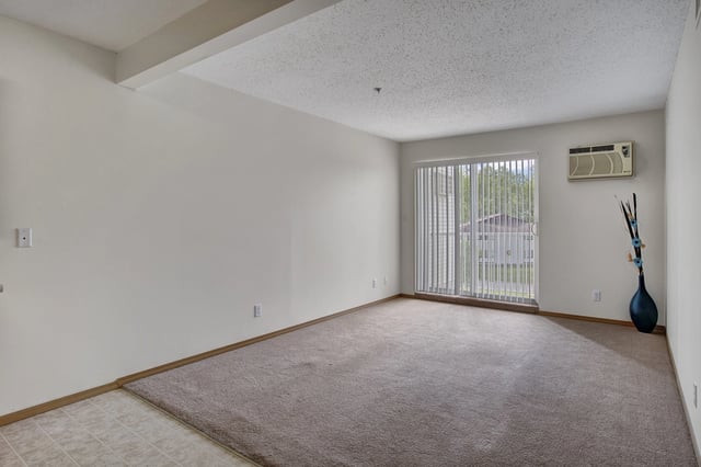 Living room with sliding glass door and air conditioning unit.
